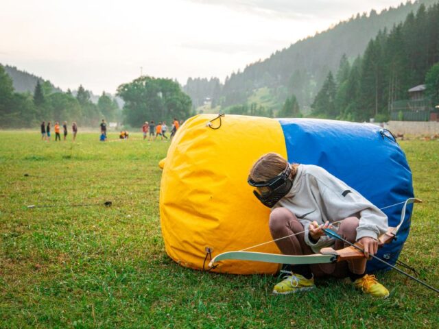 Girl playing archery tag on a field
